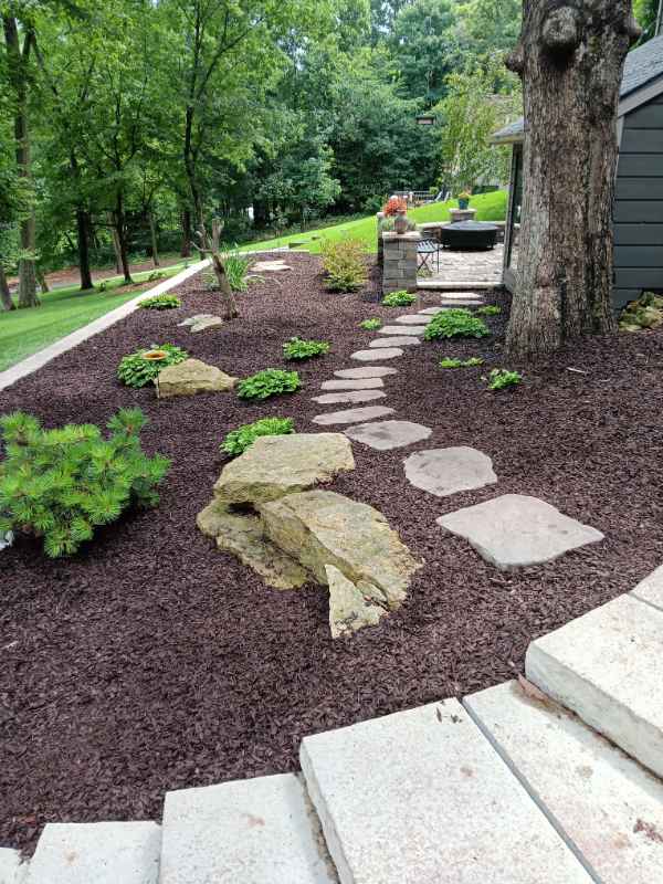 Stone pathway in landscaped garden with trees.