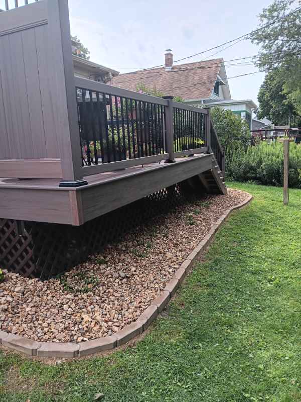 Elevated backyard deck with gravel border and stairs.