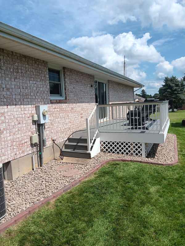 Brick house with deck and green lawn.