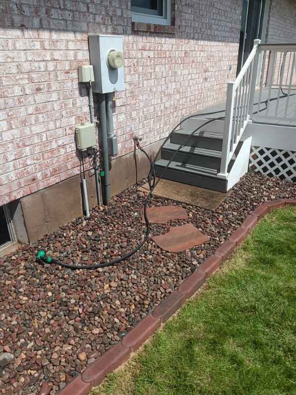 Backyard steps with gravel landscaping and hose connection.