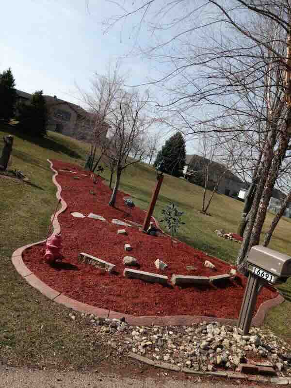 Red mulch garden with stones and trees