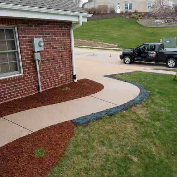 Brick house with curved sidewalk and parked truck.