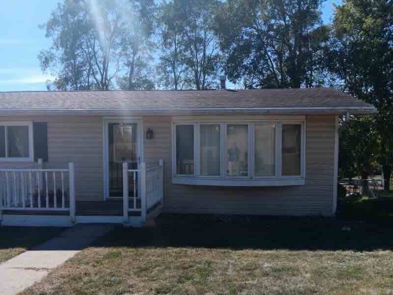 Single-story house with front porch and large window.